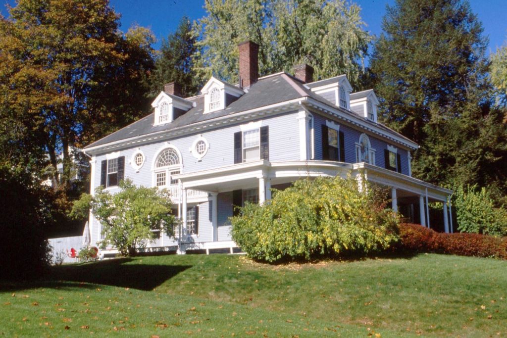 A large foursquare form Colonial Revival Style House with porch dormer and pseudo Palladian window. 