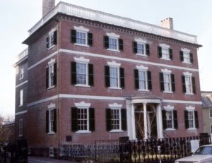 A classic brick Federal with three stories, including a low pitch roof and balustrade