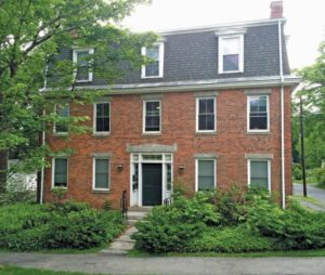 A Brick Greek Revival house with a Mansard Roof.