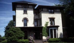 a stately Italianate style with typical low pitch roof and doubled heavy bracketing