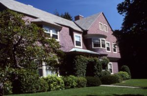 A large shingle style house featuring a sweeping roof line and gabled front. Description: 