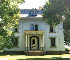 A hybrid style house with Greek Revival body, Mansard roof, and Italianate lintels.