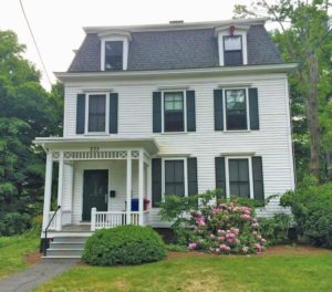 A house with a Mansard Roof and Stick-Style porch.