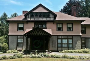 Shingle/Tudor style home with a matching carriage house, and a wonderful screened outbuilding with a stone foundation.