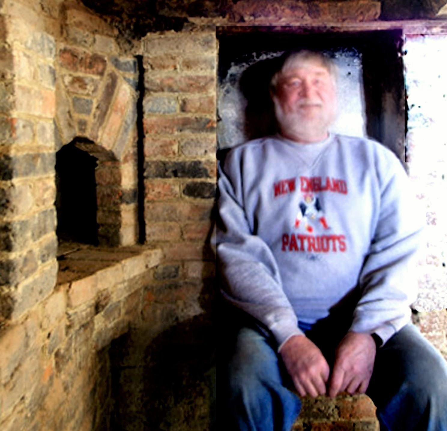 Richard Irons sitting in a First Period Home brick inglenook.